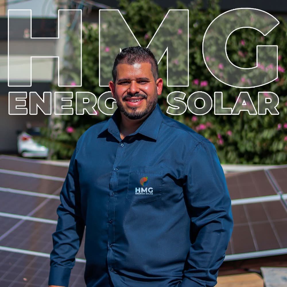 Augusto, fundador da HMG Energia Solar, em cima de um telhado com painéis solares instalados